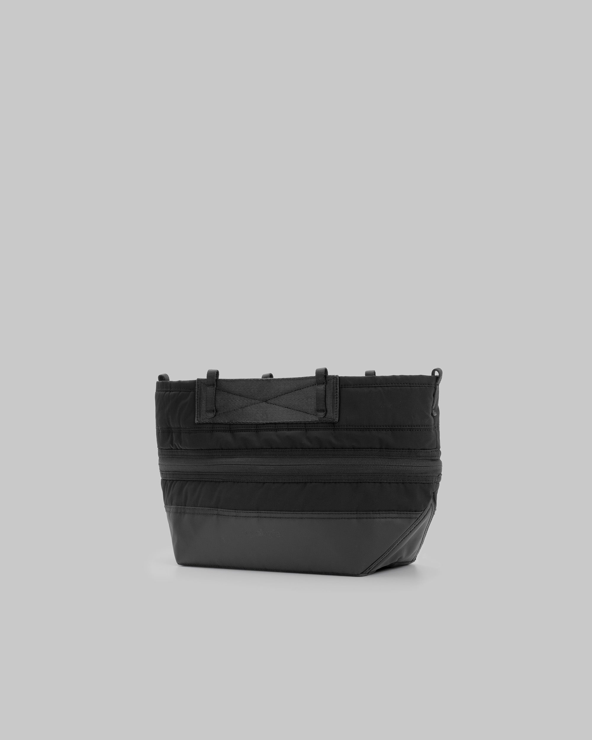 Convert Tool Bag in black puffer fabric with smooth panels and tonal hardware, shown against a light grey background.