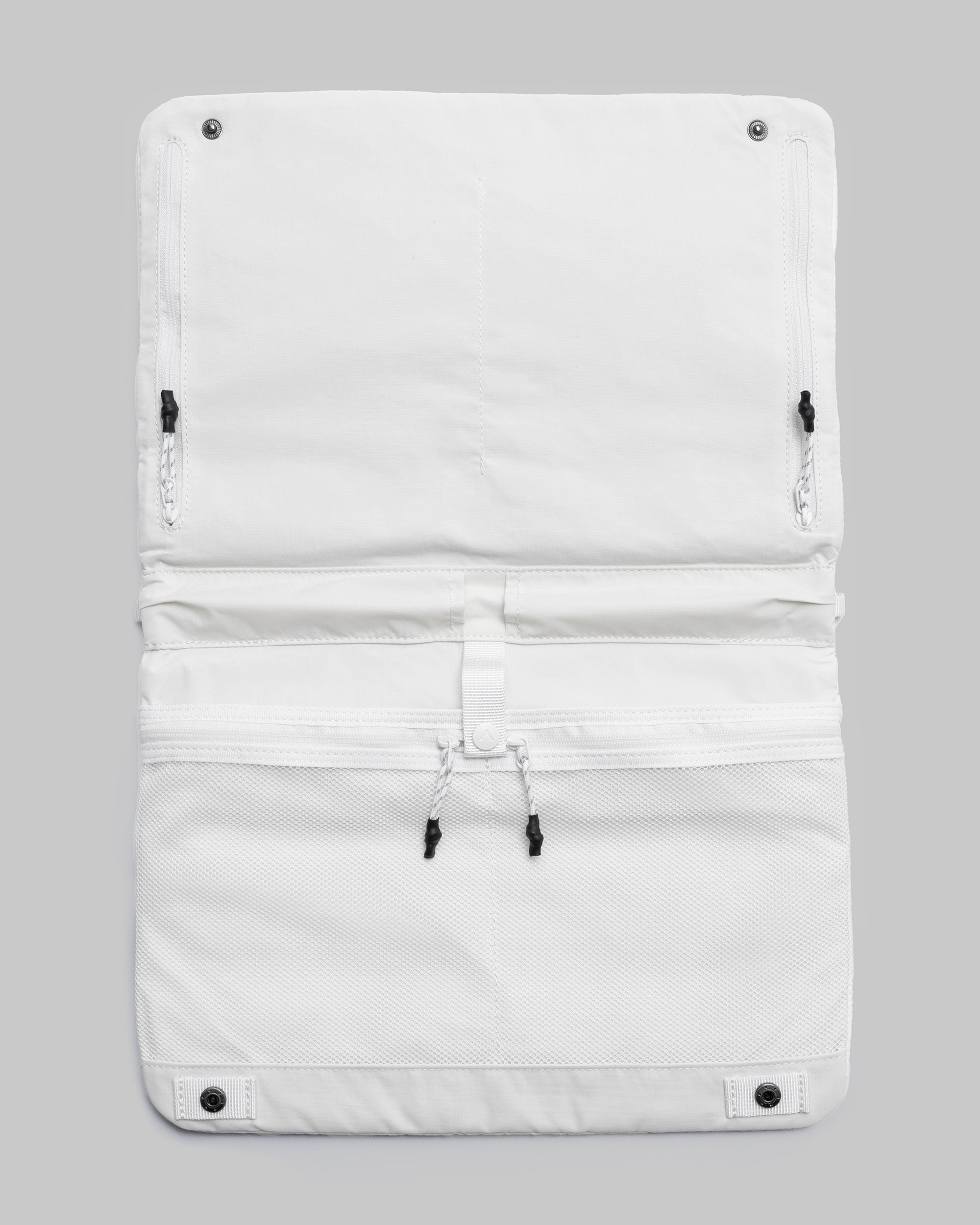 Flat Sacoche Large in marshmallow white, shown open with a mesh pocket, zippered compartments, and black snap buttons against a light grey background.