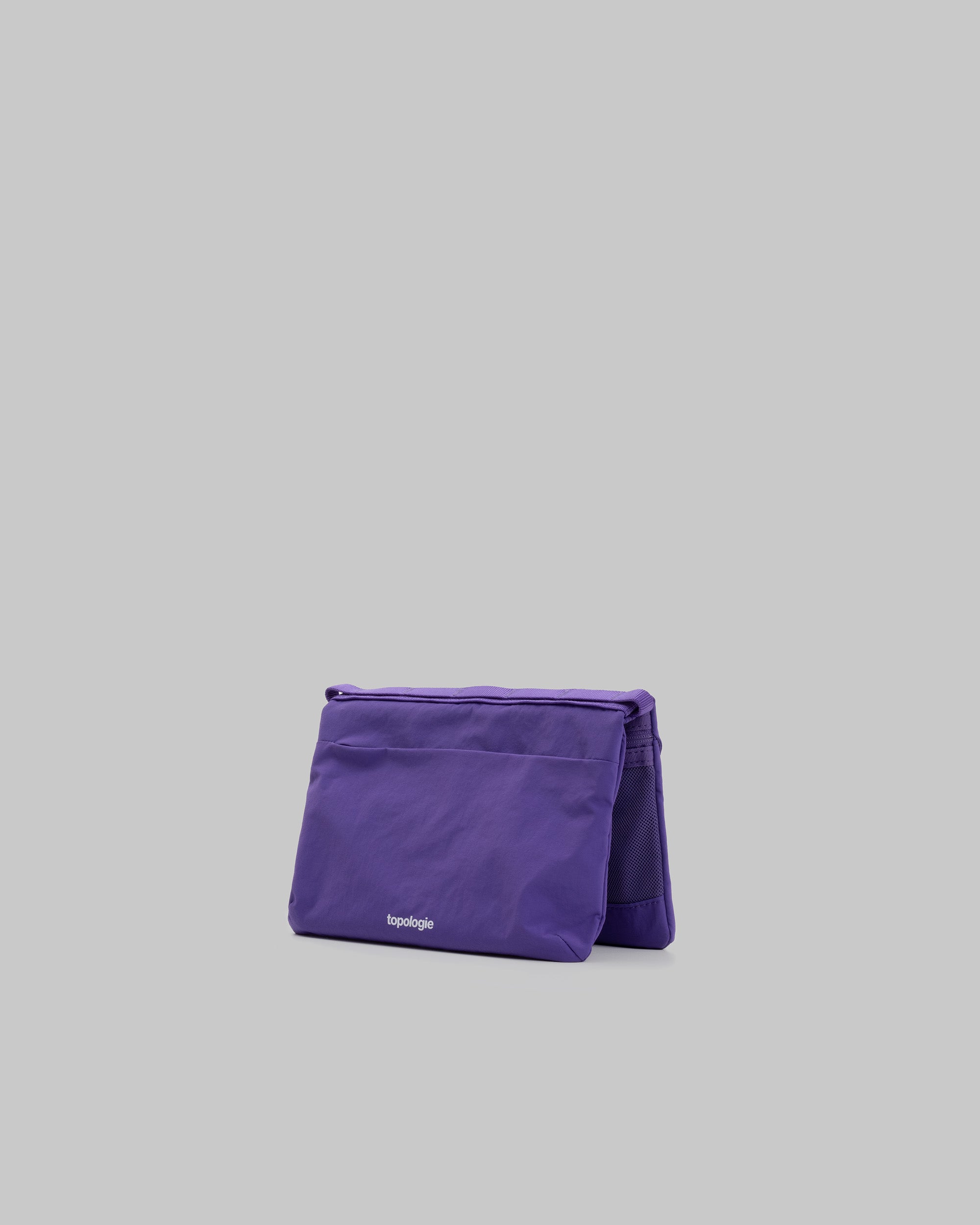 Flat Sacoche Small in purple with a white topologie logo and mesh side panel, shown against a light grey background.