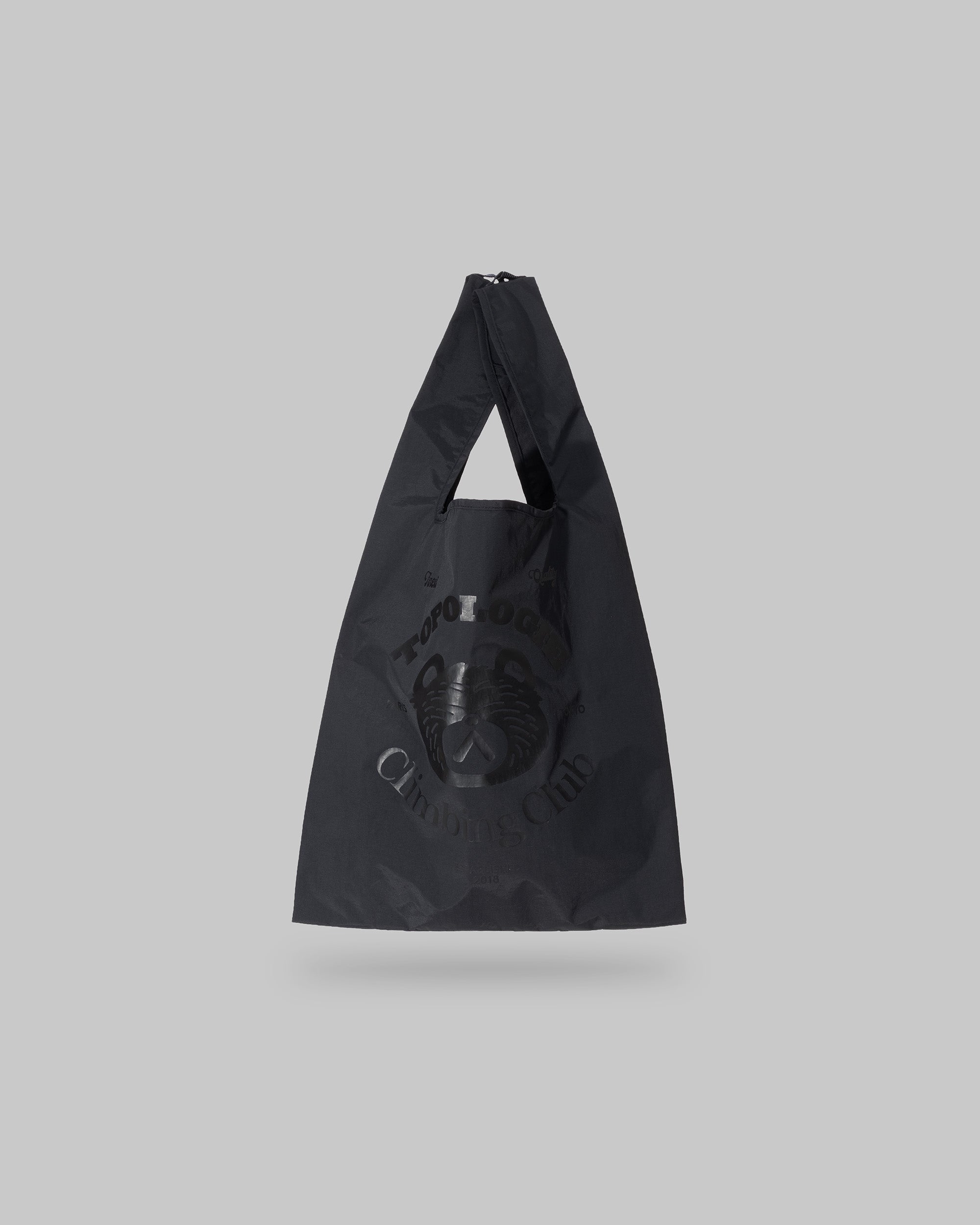 Konbini Bag Medium in black with a tonal Climbing Club bear graphic and glossy nylon body, shown against a light grey background.