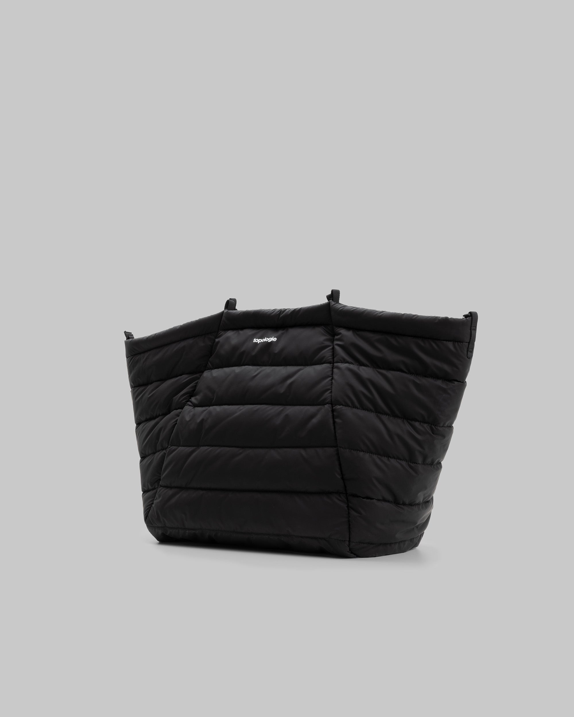 Marche Tote Large in black quilted fabric with a white topologie logo, shown against a light grey background.