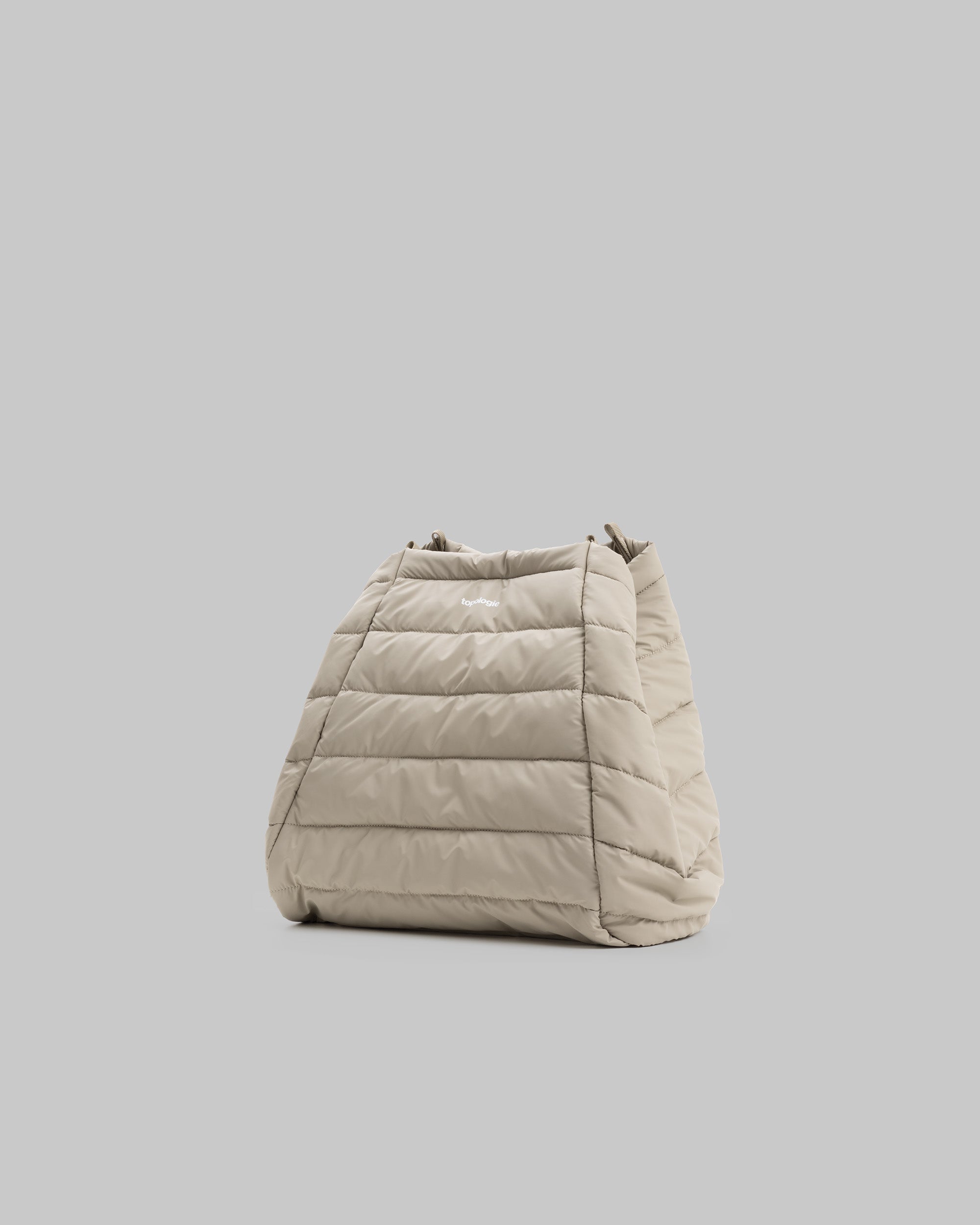 Marche Tote Large in light beige quilted fabric with a white topologie logo, shown against a light grey background.