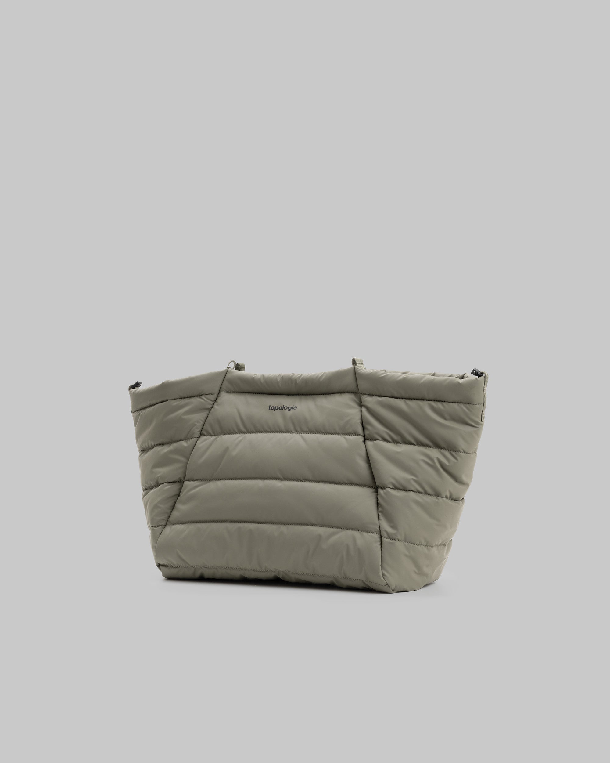 Marche Tote Medium in moss quilted fabric with horizontal padding and a small black topologie logo, shown against a light grey background.