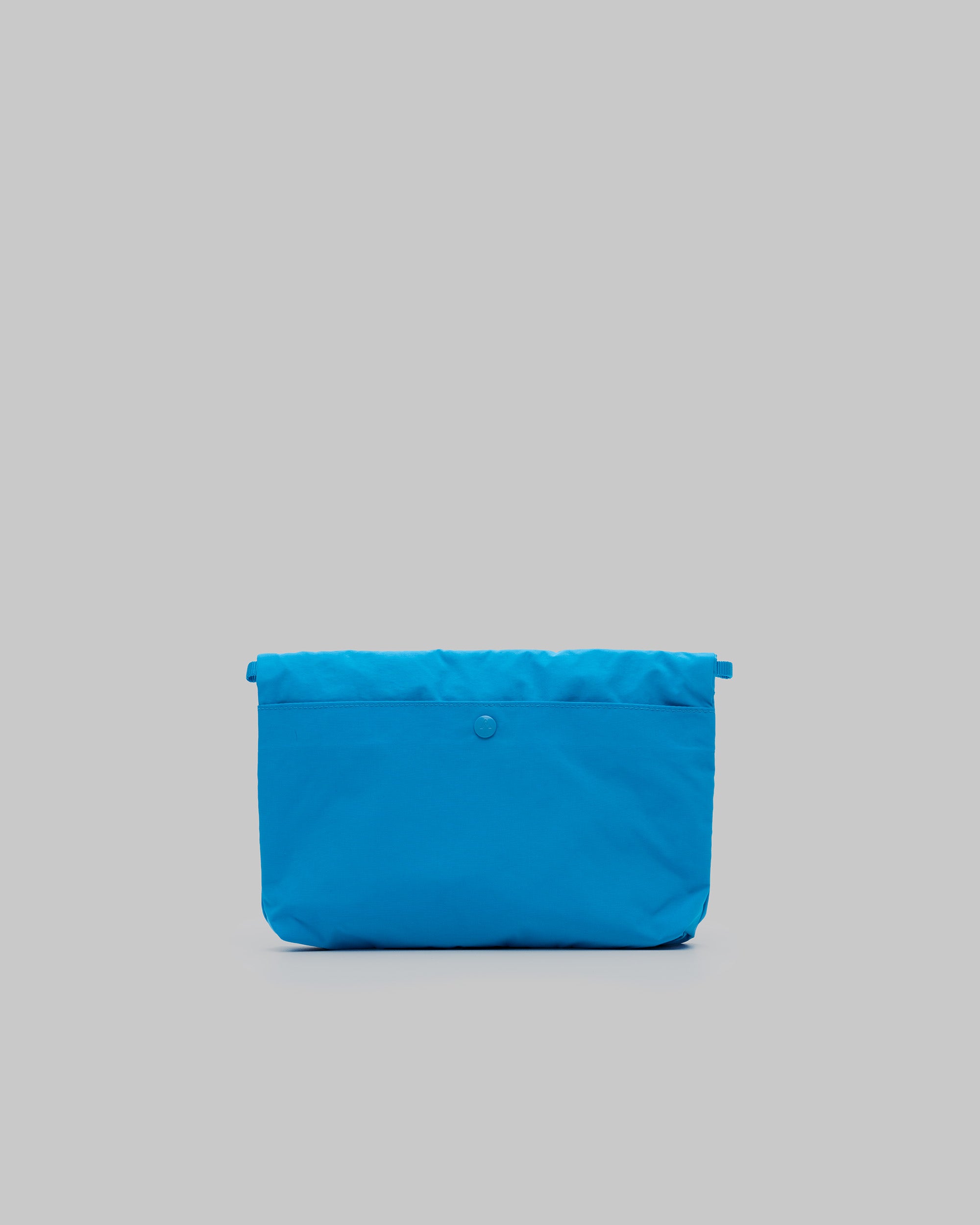 Musette Medium in atomic blue with a snap closure and side loops, shown against a light grey background.
