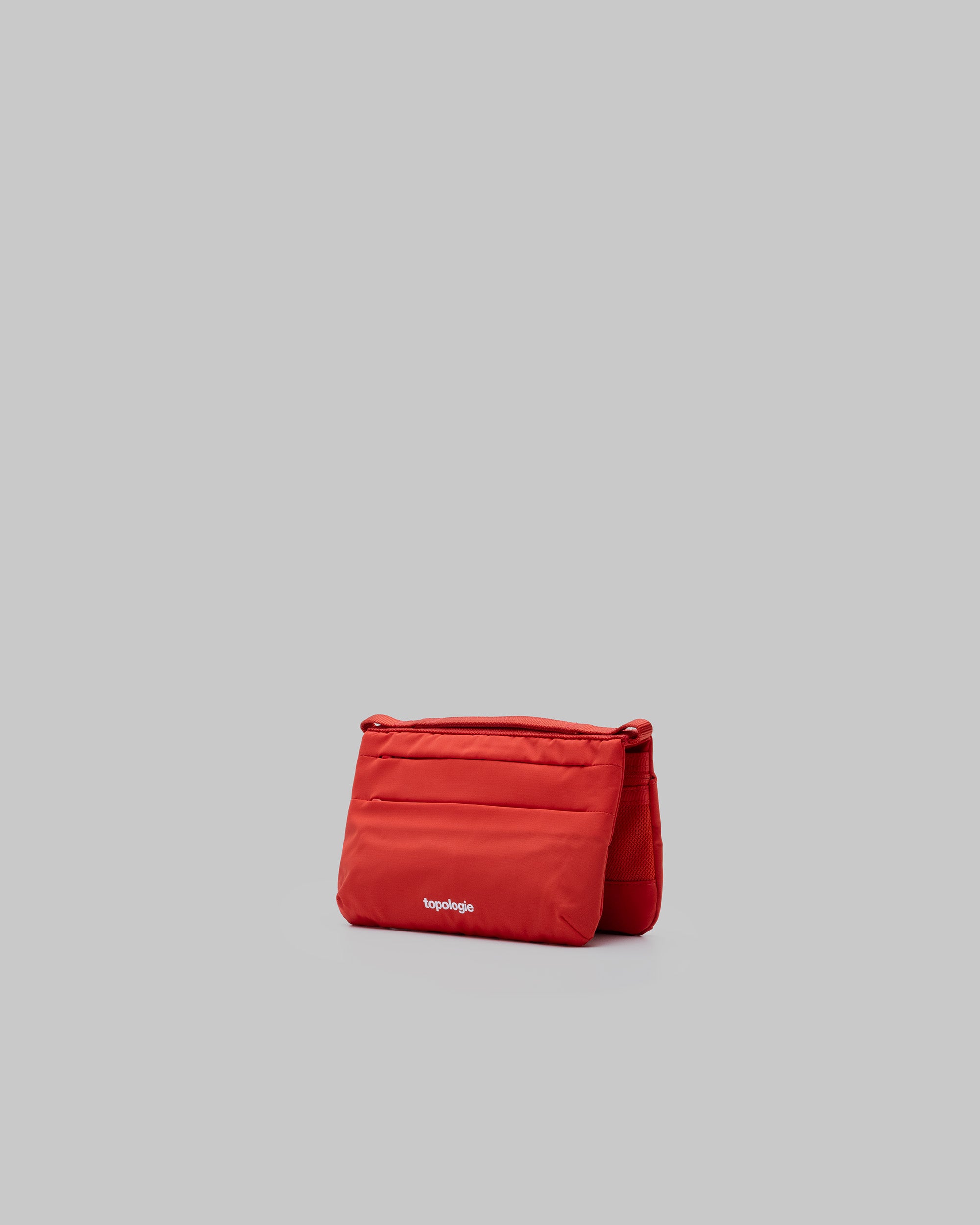 Phone Sacoche 90 in topologie red with front slip pockets and a white topologie logo, shown against a light grey background.