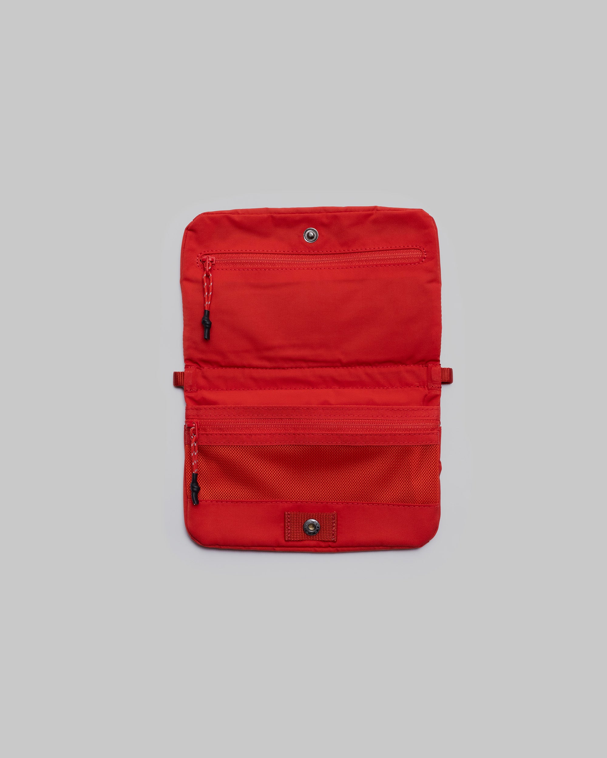 Phone Sacoche 90 in red shown open with zippered pockets and a mesh compartment, against a light grey background.
