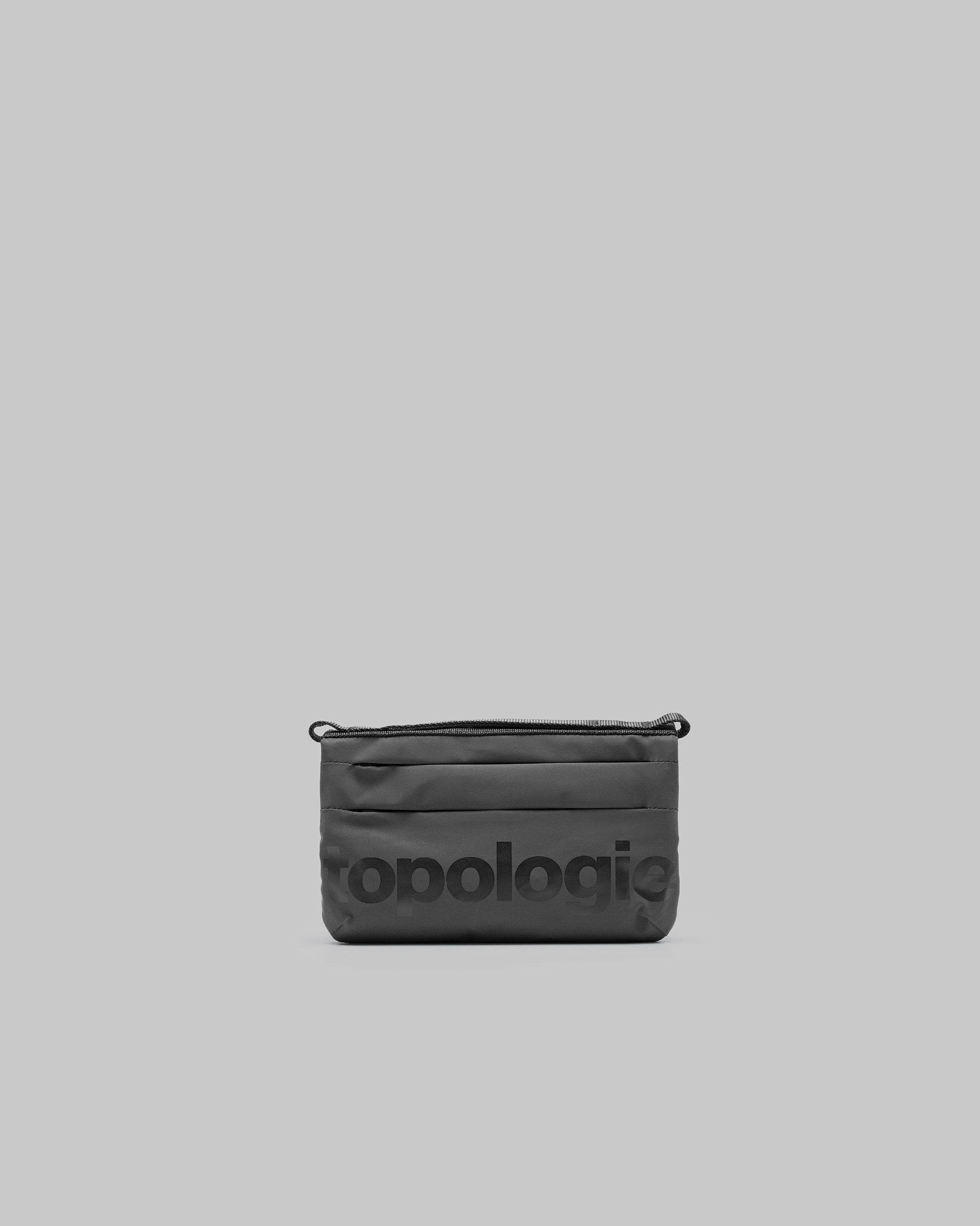 Phone Sacoche 90 in dark grey with a large tonal topologie logo and horizontal seams, shown against a light grey background.